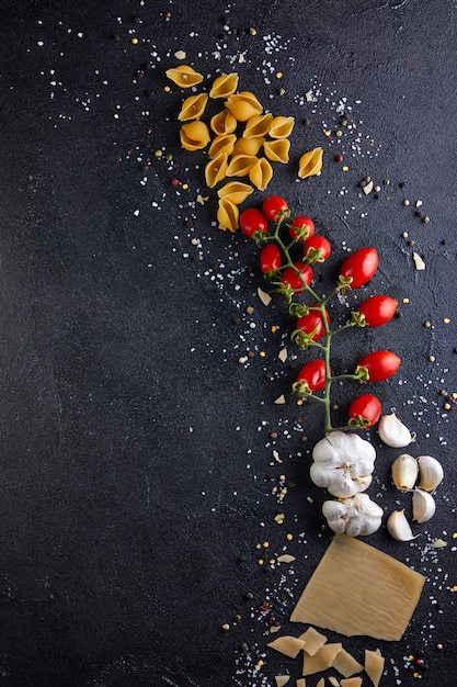 Ingrédients pour la cuisson des pâtes sur fond noir.