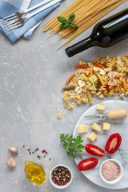 Ingrédients pour la cuisson des pâtes traditionnelles - fromage, tomates, condiments.