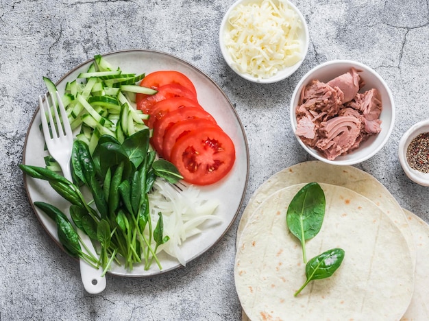 Ingrédients pour la cuisson des quesadillas thon en conserve légumes fromage et tortillas sur fond gris vue de dessus