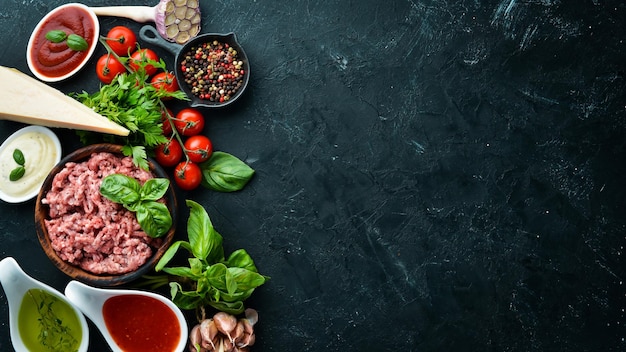 Ingrédients pour la cuisson de la sauce bolognaise Sur fond noir Vue de dessus Espace libre pour votre texte