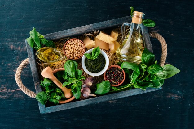 Ingrédients pour la cuisson de la sauce pesto dans une boîte en bois Basilic parmesan huile d'olive pignons poivre ail Vue de dessus