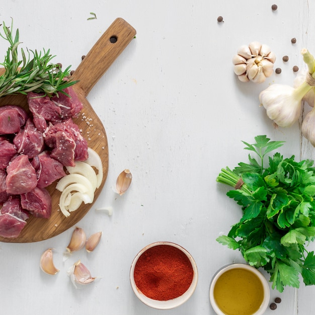 Ingrédients pour la cuisson de la viande avec des légumes sur la vue de dessus de fond en bois blanc. Préparation boeuf mea