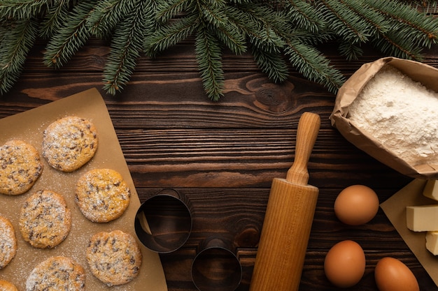 Les ingrédients pour faire des biscuits de Noël sont sur une table en bois