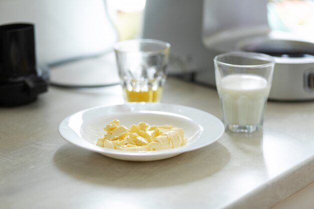 Ingrédients pour faire de la crème douce. Le beurre fond dans une assiette