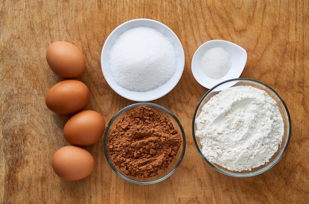 Ingrédients pour faire du gâteau au chocolat sur le vieux fond en bois