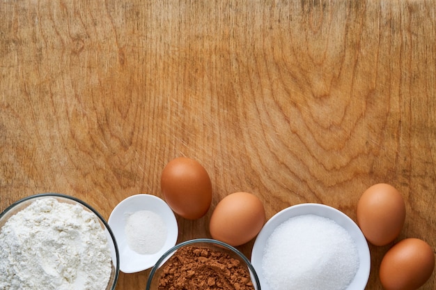 Ingrédients pour faire du gâteau au chocolat sur le vieux fond en bois