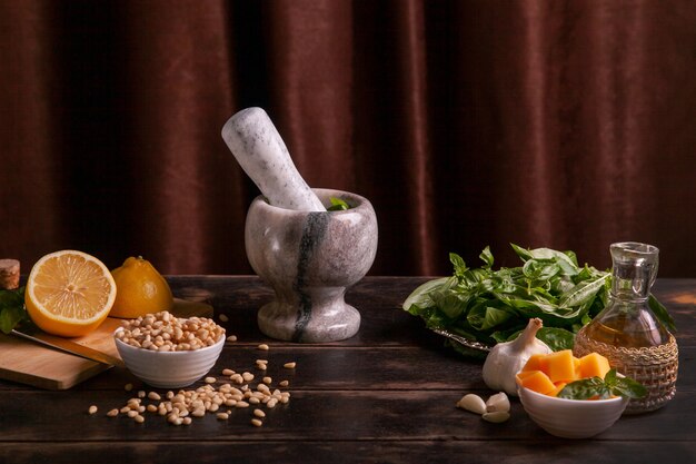 Ingrédients pour faire du pesto sauce basilic à la maison à l'aide d'un mortier et d'un pilon.