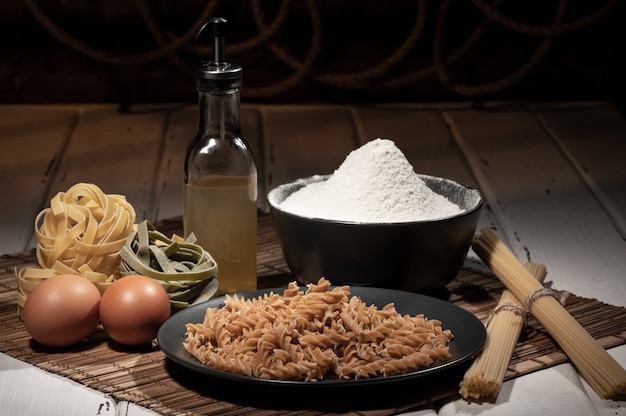 Ingrédients pour faire des pâtes sur une table en bois