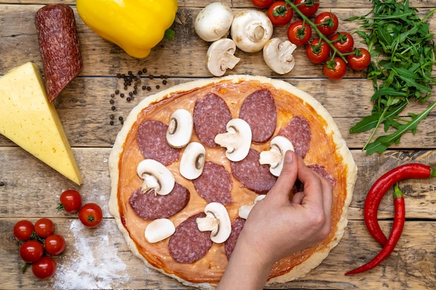 Ingrédients Pour Faire Des Pizzas, Avant La Cuisson, Sur Une Table En Bois, Vue De Dessus à La Main Disposés De Champignons