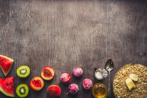 Photo ingrédients pour la farine d'avoine sur une table en bois sombre. concept d'alimentation saine. vue de dessus, copiez l'espace. mise à plat. nature morte. tonique