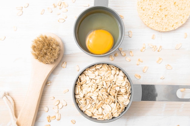 Ingrédients pour un masque cosmétique fait maison sur une table en bois flocons d'avoine et œuf pour renforcer les cheveux