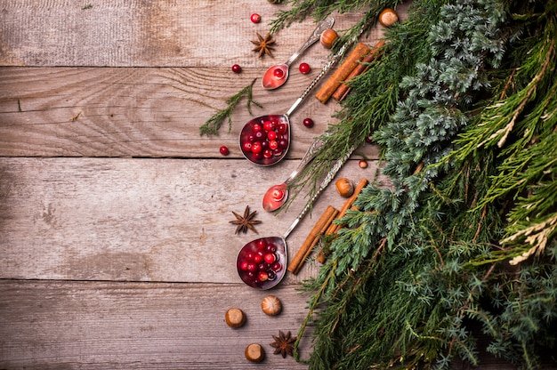 Ingrédients pour Noël, biscuits de cuisson d'hiver. Pain d'épices, gâteau aux fruits, boissons de saison. Canneberges, oranges séchées, cannelle, épices sur une table en bois, copie vue de dessus de l'espace.