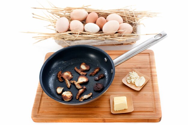 Ingrédients pour omelette aux champignons sur une planche à découper