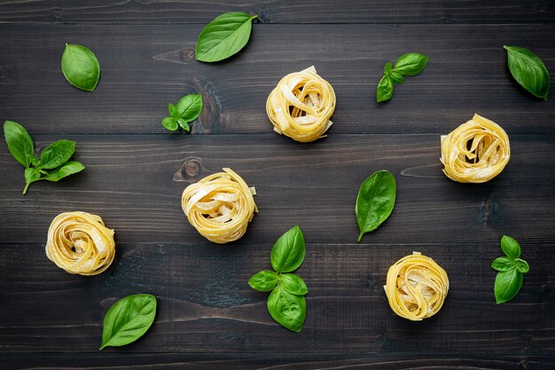 Ingrédients pour les pâtes faites maison sur un fond en bois foncé.