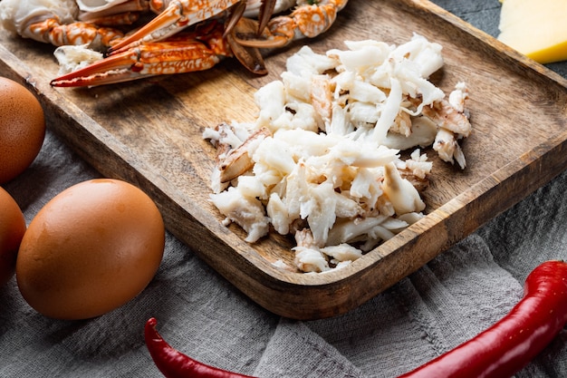 Ingrédients pour le petit-déjeuner omelette avec de la viande de crabe et du fromage, sur table grise