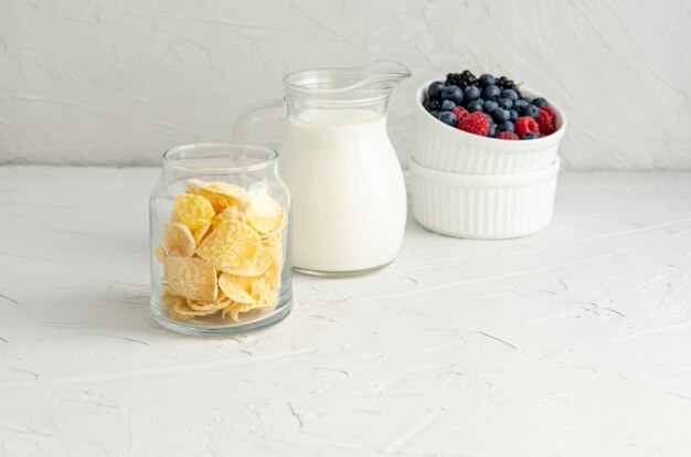 Ingrédients pour un petit déjeuner sain - cornflakes, baies, lait