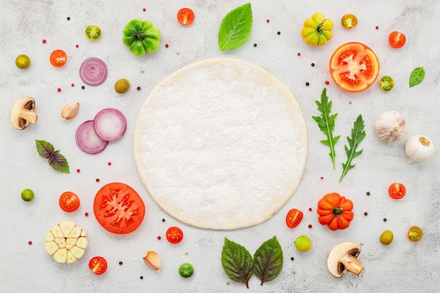 Les ingrédients pour la pizza maison mis en place sur fond de béton blanc à plat et copiez l'espace.