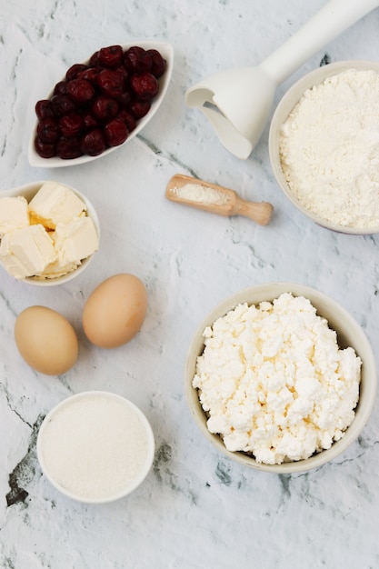 Ingrédients pour la préparation du gâteau aux cerises: farine, levure chimique, œufs, fromage cottage, beurre, sucre et cerise