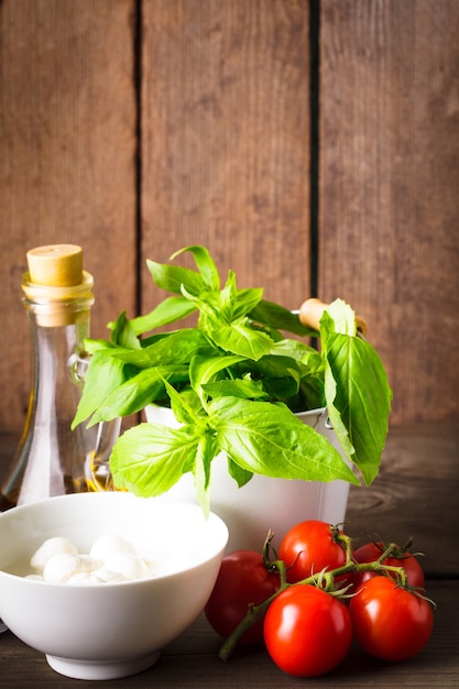 Photo ingrédients pour salade caprese sur mur en bois, cuisine italienne