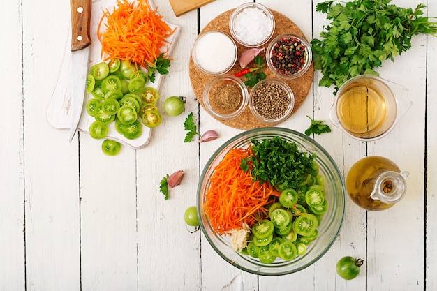 Ingrédients pour la salade coréenne de tomates vertes et de carottes. Plat poser. Vue de dessus