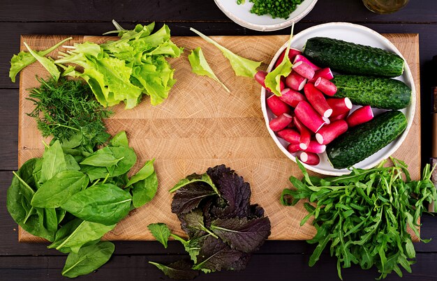 Ingrédients pour salade fraîche de concombres, radis et herbes. Lay plat. Vue de dessus