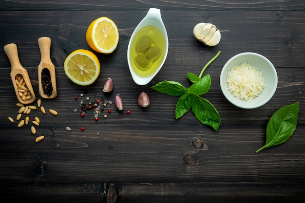 Les ingrédients pour la sauce pesto verte sur un fond en bois foncé.