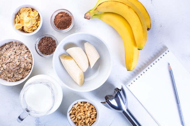 Ingrédients pour Smoothie à la banane sur fond blanc. Concept d'alimentation saine.