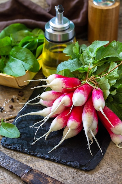 Ingrédients de la salade d'été légumes biologiques et huile d'olive Radis juteux frais cru sur une table rustique