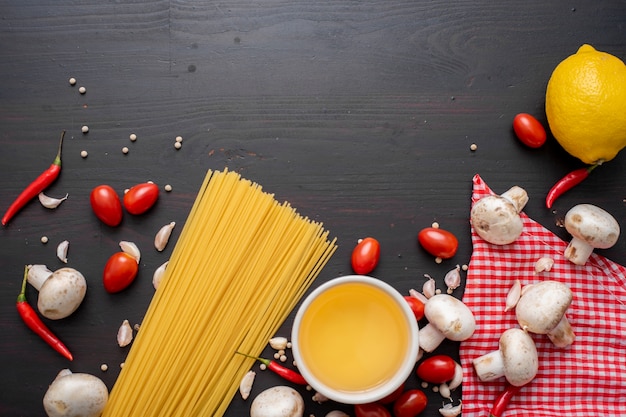 Ingrédients Spaghetti sur un bureau en bois noir, vue de dessus.