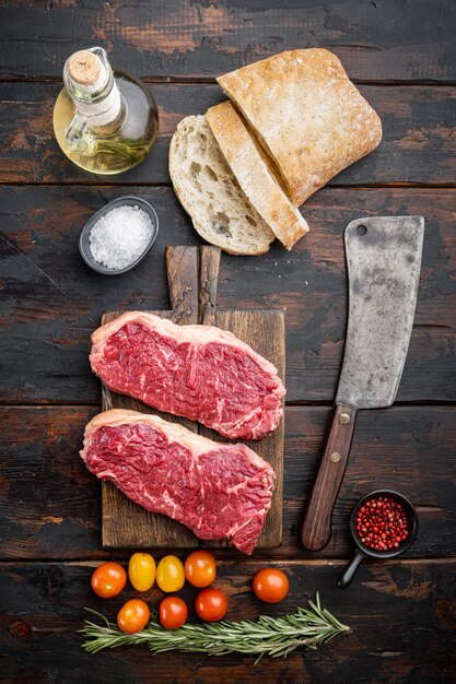 Ingrédients de steak de boeuf cru, avec de la viande marbrée, sur la vieille table en bois, vue du dessus,