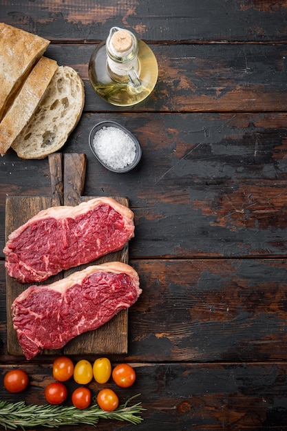 Ingrédients de steak de boeuf cru, avec de la viande marbrée, sur la vieille table en bois, vue du dessus,