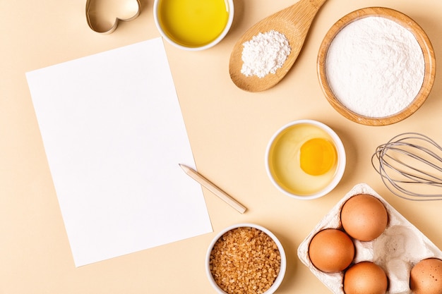 Ingrédients et ustensiles pour la cuisson sur fond pastel, vue de dessus.