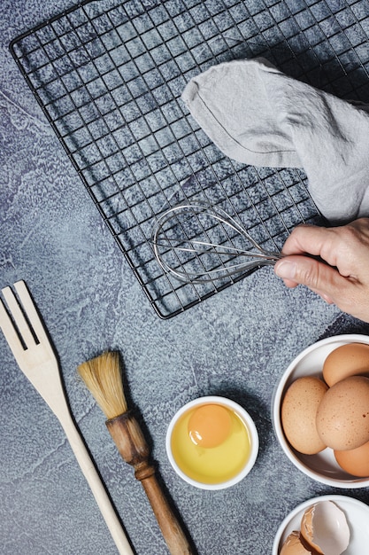 Ingrédients et ustensiles pour préparer un gâteau sur une surface bleue. Oeufs, farine, cannelle, lait. Vue de dessus. Copiez l'espace.