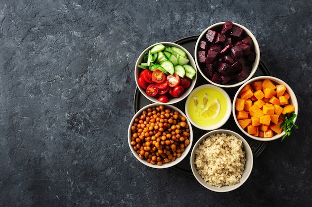 Ingrédients végétariens sains pour la cuisson de la salade marocaine. Pois chiches, potiron et betteraves au four, quinoa et légumes.