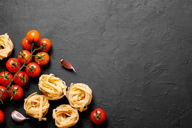 Ingridients biologiques frais de recettes italiennes. Pâtes, tomates, ail. Concept de nourriture saine.