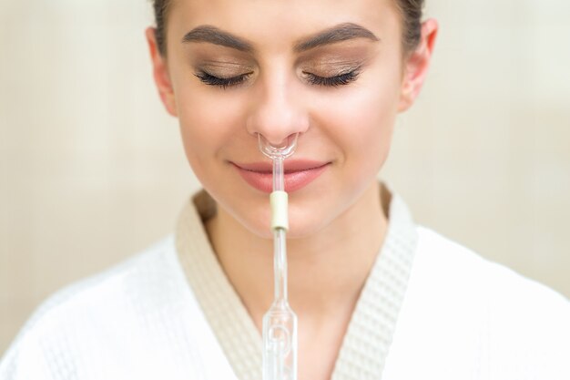 Inhalation nasale Maholda dans le nez d'une jeune femme.