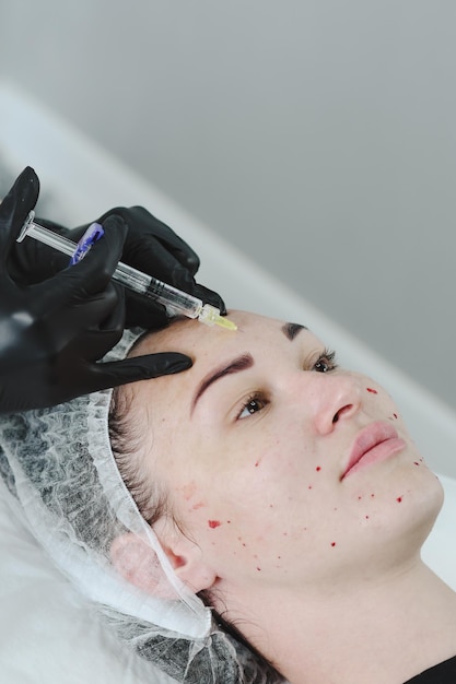 Injection de cosmétologie cosmétologue donne une injection sur le visage injections de beauté