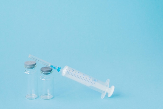 Injection médicale sur fond bleu Idée créative pour le coût des soins de santé pharmacie assurance maladie et entreprise pharmaceutique concept d'entreprise Espace de copie