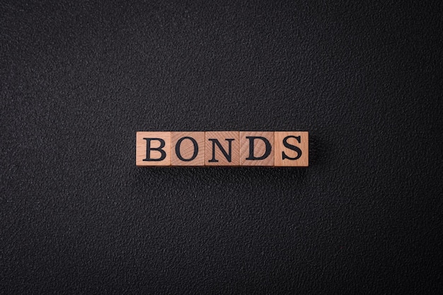 L'inscription Bonds faite de cubes de bois sur un fond plat.