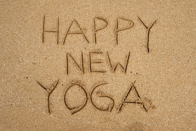 Inscription sur le bord de mer de sable Happy New Yoga