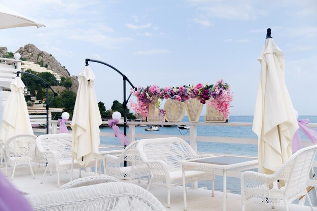 Inscription décorative LOVE avec ampoules à l'intérieur sur la véranda d'un café d'été Beau paysage marin avec des montagnes en arrière-plan