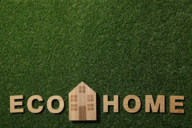 L'inscription eco maison en lettres de bois sur l'herbe
