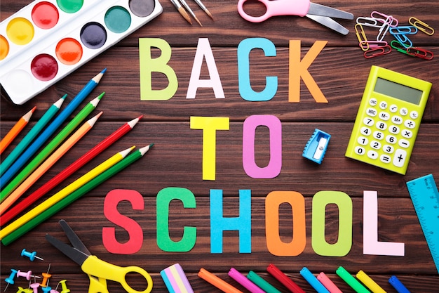 Photo inscription à l'école avec des fournitures scolaires sur fond en bois marron