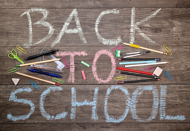 Inscription à l&#39;école avec des outils scolaires sur un fond en bois