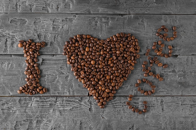 L&#39;inscription J&#39;aime le café fait à partir de grains de café torréfiés sur une table en bois noire.