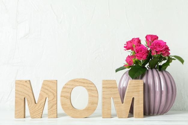 Inscription maman et vase avec roses roses sur tableau blanc