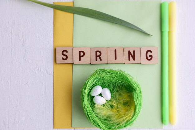 Inscription printemps et articles de Pâques sur fond blanc