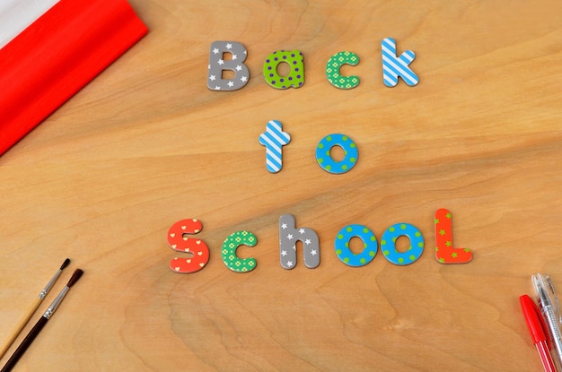 L'inscription retour à l'école des lettres de l'alphabet des enfants sur le bureau