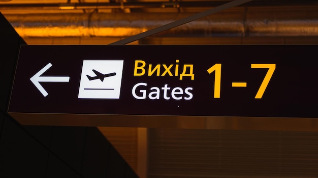 Photo inscrivez-vous à la porte sur un panneau jaune à l'aéroport ukrainien la traduction d'un mot étranger est une sortie