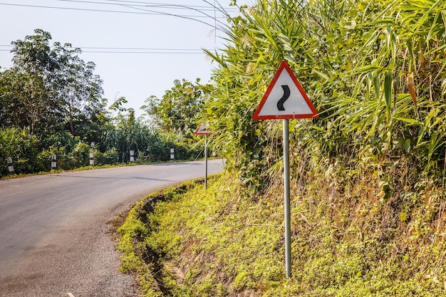 Inscrivez-vous sur une route sinueuse sur une route de montagne panneau de signalisation d'avertissement Laos